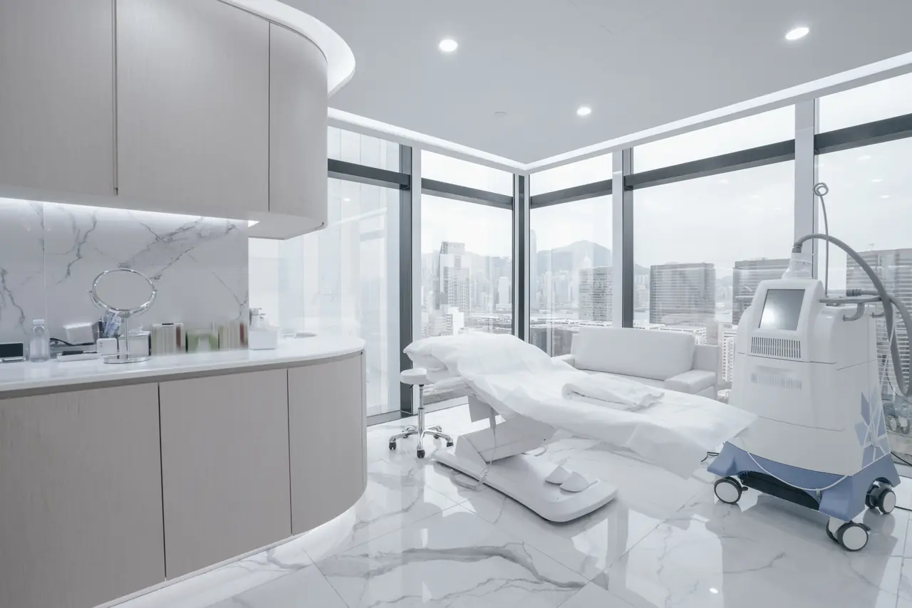 A bright, modern treatment room with a couch and treatment equipment
